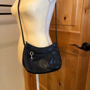 Fossil black leather cross body purse w/inside & outside pockets.